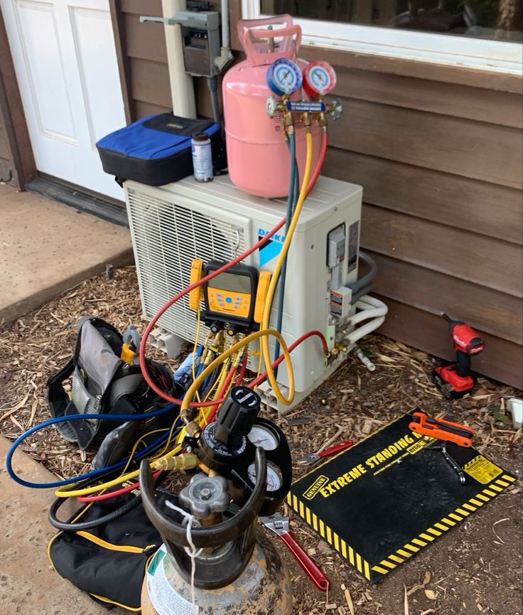 Air conditioning maintenance tools and gauges connected to an outdoor unit