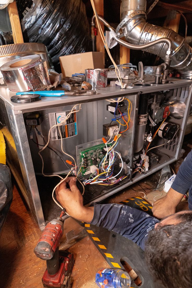 Technician repairing the wiring and controls inside a residential heating system